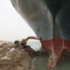 An excavator attempts to free stranded container ship Ever Given, one of the world's largest container ships, after it ran aground, in the Suez Canal.